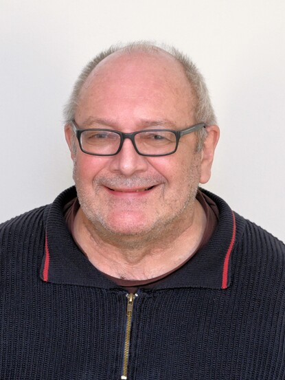 Mann mit lächeln um Gesicht und Brille